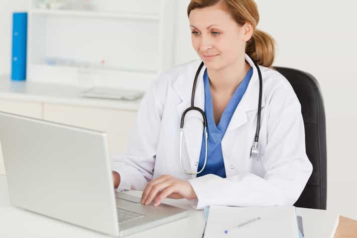 Female doctor working on her laptop in her office