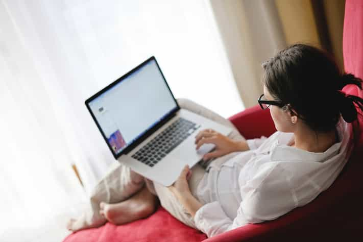 happy young woman working from home on sofa